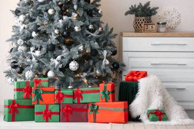 İçinde hediyeler ve oturma odasında Noel ağacı olan puf.