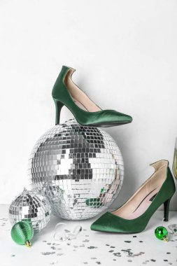 Topuklu disko topu ve beyaz arka planda Noel dekoru.