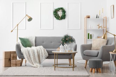 Oturma odasının içinde mum tutacağı ve Noel çelengi var.