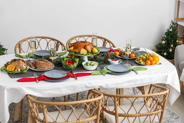 Christmas table setting with tasty meat and vegetables in dining room