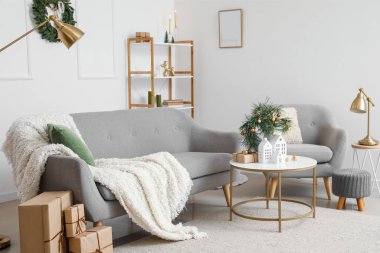 Oturma odasının içinde ev şeklinde mum tutacakları ve Noel hediyeleri var.