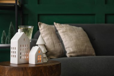 Oturma odasındaki masada mum tutacakları ve bir bardak şampanya.