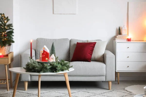 Interior of living room with candle holders, Christmas tree and sofa