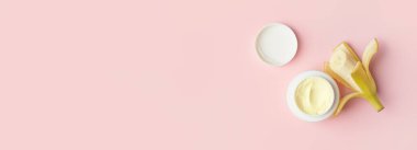 Pembe zemin üzerinde doğal muz kreması kavanozu ve metin için boşluk