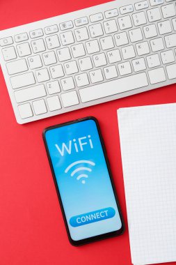 Renkli arka planda klavye, defter ve cep telefonu