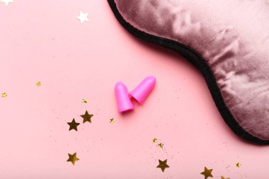 Earplugs and sleeping mask on pink background clipart