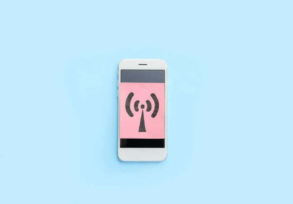 Mobile phone and paper sheet with WiFi symbol on color background