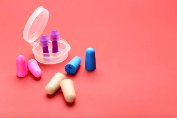 stock image Plastic container and different earplugs on color background