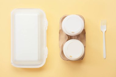 Yiyecek kutusu, kağıt bardak ve renk arkaplan çatalı.