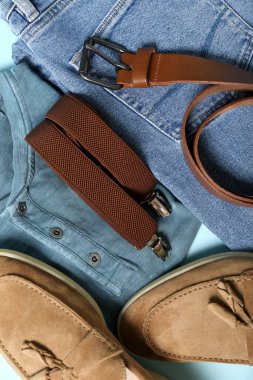 Mavi arka planda erkek giysileri, ayakkabılar ve aksesuarlar, yakın plan