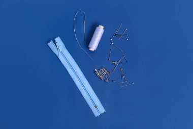 Mavi arka planda iplik makaralı dikiş malzemeleri.