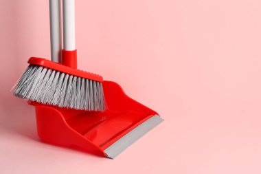 Pembe arka planda süpürge ve faraş