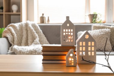 Oturma odasındaki masada mum tutacakları ve kitaplar.