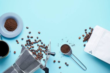 Gayzer kahve makinesi ve mavi arkaplanda fasulye bileşimi