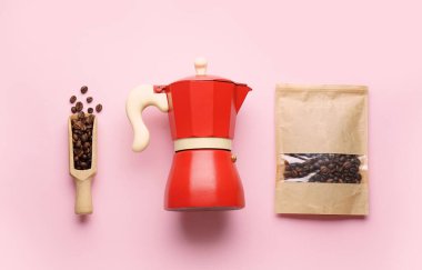 Gayzer kahve makinesi, pembe arka planda fasulye kepçesi ve poşet