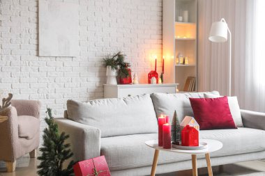 Oturma odasının içinde mum tutacağı, kanepe ve Noel hediyeleri var.