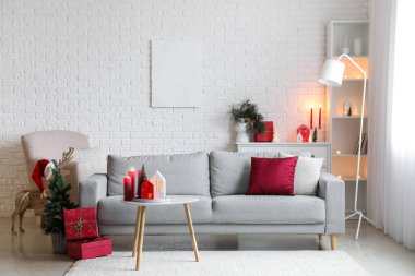 Oturma odasının içinde mum tutacağı, kanepe ve Noel hediyeleri var.