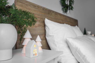 Kozalaklı vazolar, mum tutacağı ve yatak odasındaki Noel ağaçları.