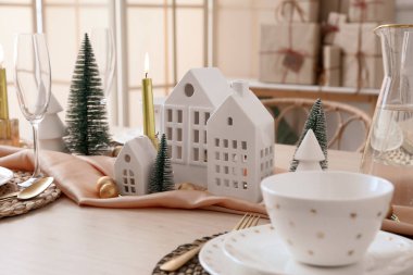 Yemek odasında mum tutucuları ve Noel ağaçları olan masa ayarları, yakın plan.