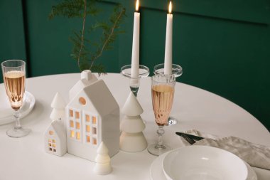 Yemek odasında mum tutucuları ve Noel ağaçları olan masa ayarları, yakın plan.
