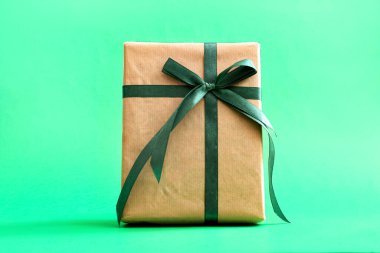 Yeşil arka planda kurdeleli hediye kutusu