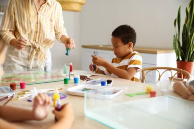 Ebru resim atölyesindeki küçük Afro-Amerikalı çocuk.