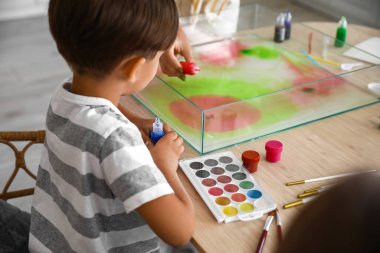 Küçük çocuk atölyede Ebru 'nun resim atölyesinde oturuyor, yakın plan.