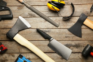 Ahşap arka planda işçi malzemesi olan baltalar.