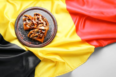 Lezzetli waffle tabağı ve arka planda Belçika bayrağı.