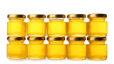 Beyaz arka planda kavanozlarda lezzetli bal