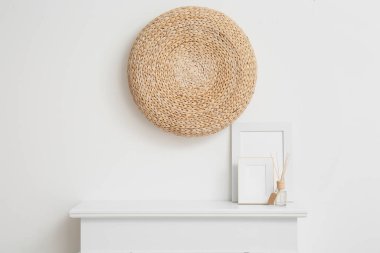 Dekorlu beyaz duvarın yanındaki şömine rafında boş kartla fotoğraf çerçeveleri ve sazlık dağıtıcı