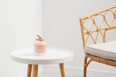 Beyaz duvarın yanındaki masada şık bir mum.