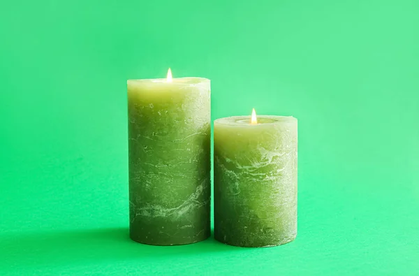 Beautiful burning candles on green background
