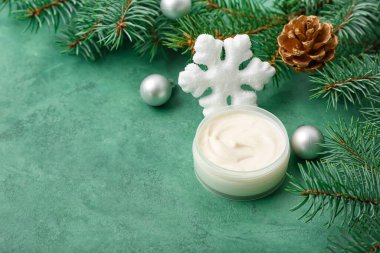 Krema kavanozlu kompozisyon, köknar dalları ve renk arkaplanı üzerine Noel süslemeleri