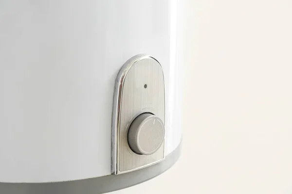 Modern electric boiler on white wall, closeup