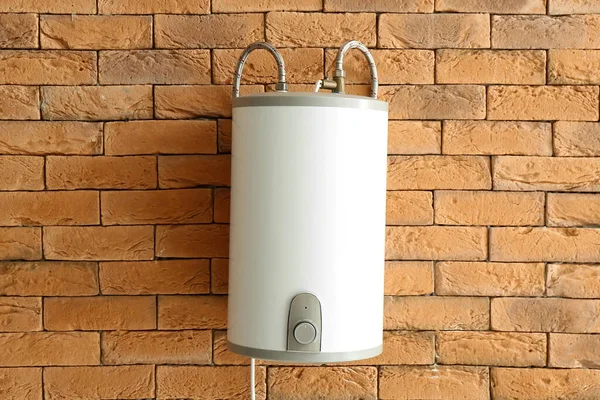 Modern electric boiler on brick wall