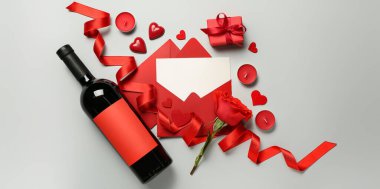 Bir şişe şarap, zarflar, gül, hediye, arka planda kalpler ve mumlar. Sevgililer Günü kutlaması