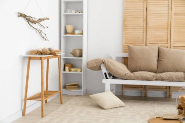 Kanepesi ve raf ünitesi olan dağınık bir oturma odası.