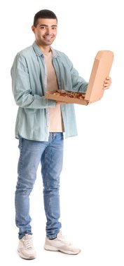 Yakışıklı genç adam beyaz arka planda taze pizza kutusunu tutuyor.