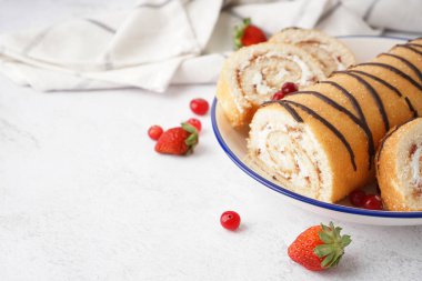 Lezzetli kek rulosu ve beyaz masada taze böğürtlen tabağı.