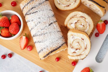 Lezzetli pandispanya rulosu ve taze böğürtlenlerle kesilmiş masa.