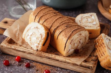 Lezzetli kek rulosu ve gri masada taze yaban mersinli kesme tahtası.