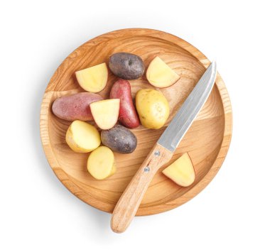 Tahta tabak, farklı tipte çiğ patates ve beyaz arka planda bıçak.