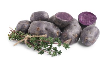 Beyaz arka planda çiğ patates ve bitkiler yığını