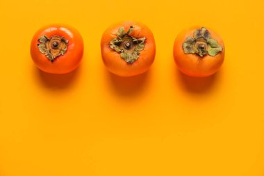 Renkli arkaplanda taze olgun hurmalar