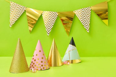 Yeşil arka planda parti şapkaları ve bayraklar