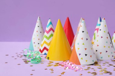 Leylak arkaplanda parti şapkaları ve konfeti