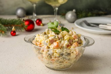 Bir kase Olivier salatası, beyaz masada, yakın plan.