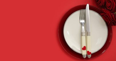 Sevgililer Günü için kırmızı zemin üzerinde kalpler ve güller olan masa ayarları ve metin için boşluk