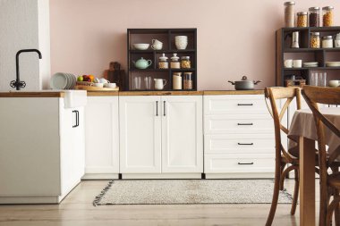 Mutfaktaki ışık duvarının yanında mutfak malzemeleri ve kavanozlarla tezgahlar.